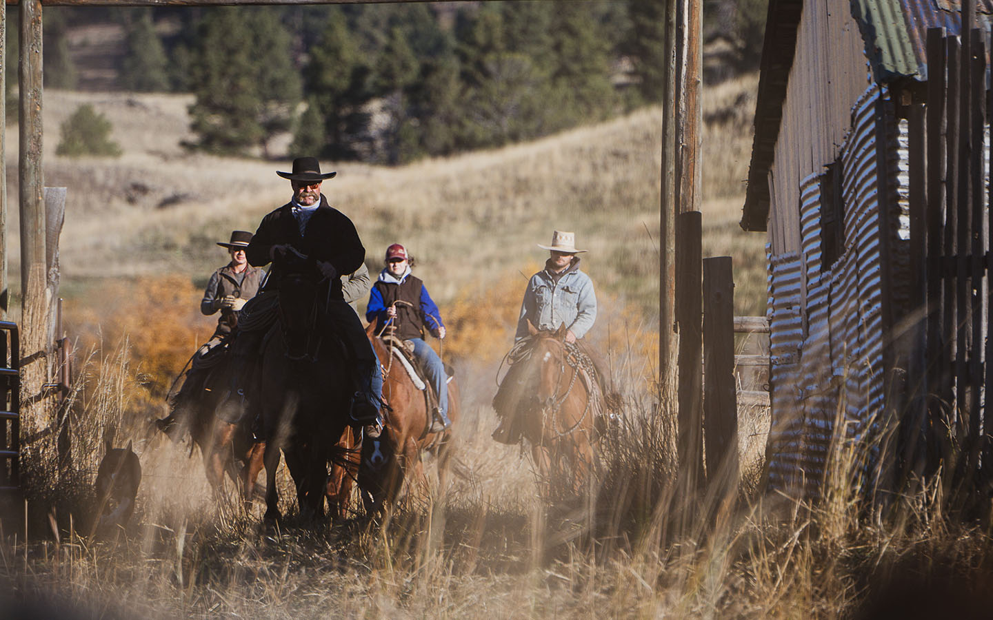 Horseback riders moving through a Yellowstone ranch.