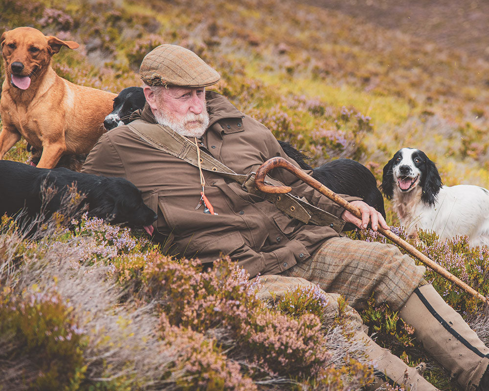 The Last Keeper Documentary - Scottish Man sitting with his dogs in a field of heather